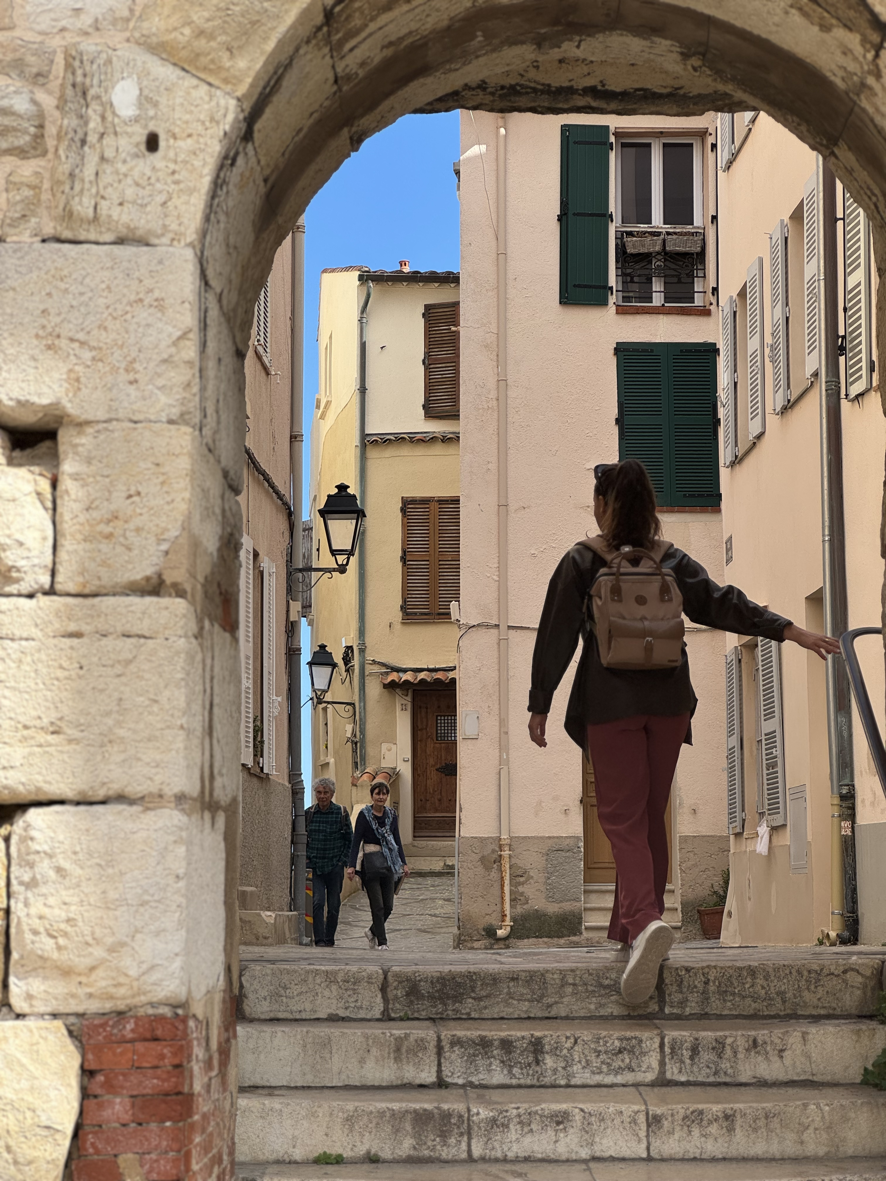 Ysa Tour guide walking in remparts and old town of Antibes through an arch