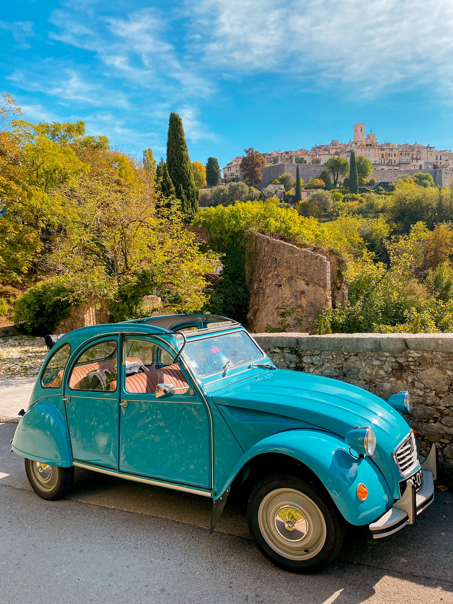Old blue 2CV car with Medieval Village of Saint-Paul-de-Vence