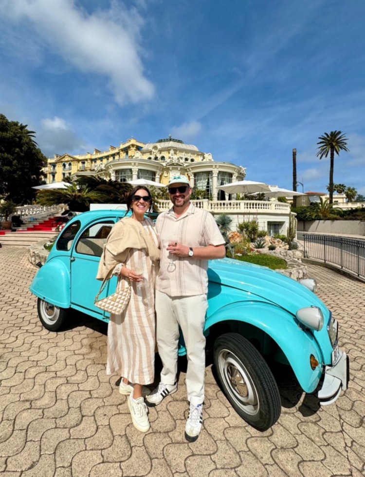 Couple standing in front of 2CV french car Côte d'Azur building